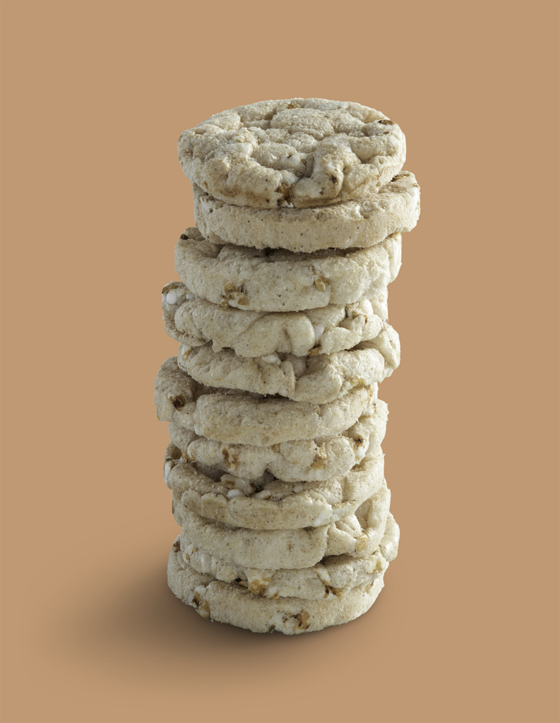 Stapel ronde gepofte graansnacks op een effen achtergrond.